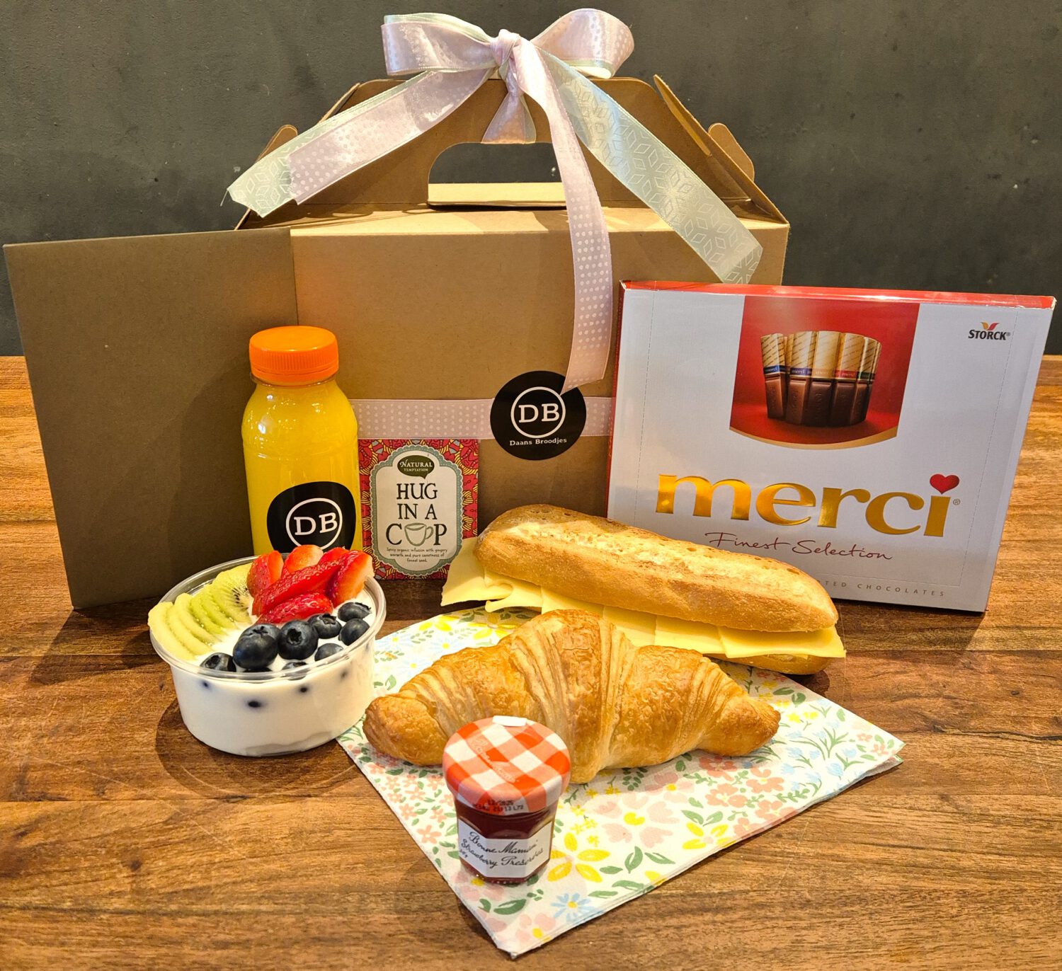 Ontbijtservice box voor moederdag om te laten bezorgen met belegde broodjes, doos merci, verse jus d'orange en yoghurt met fruit